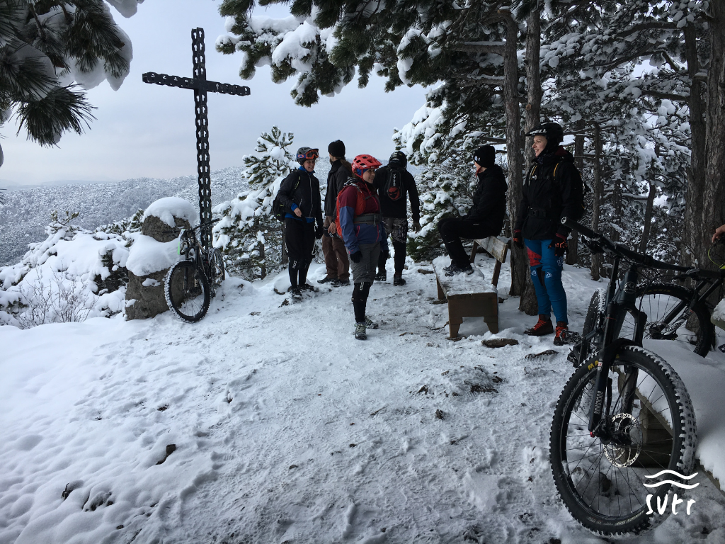 Mountainbike Gruppe am Gipfel mit Schnee
